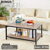 A black steel frame pours tea table with a wooden tabletop, model BFT508, placed in a living room setting with a laptop, books, and a plant on top.